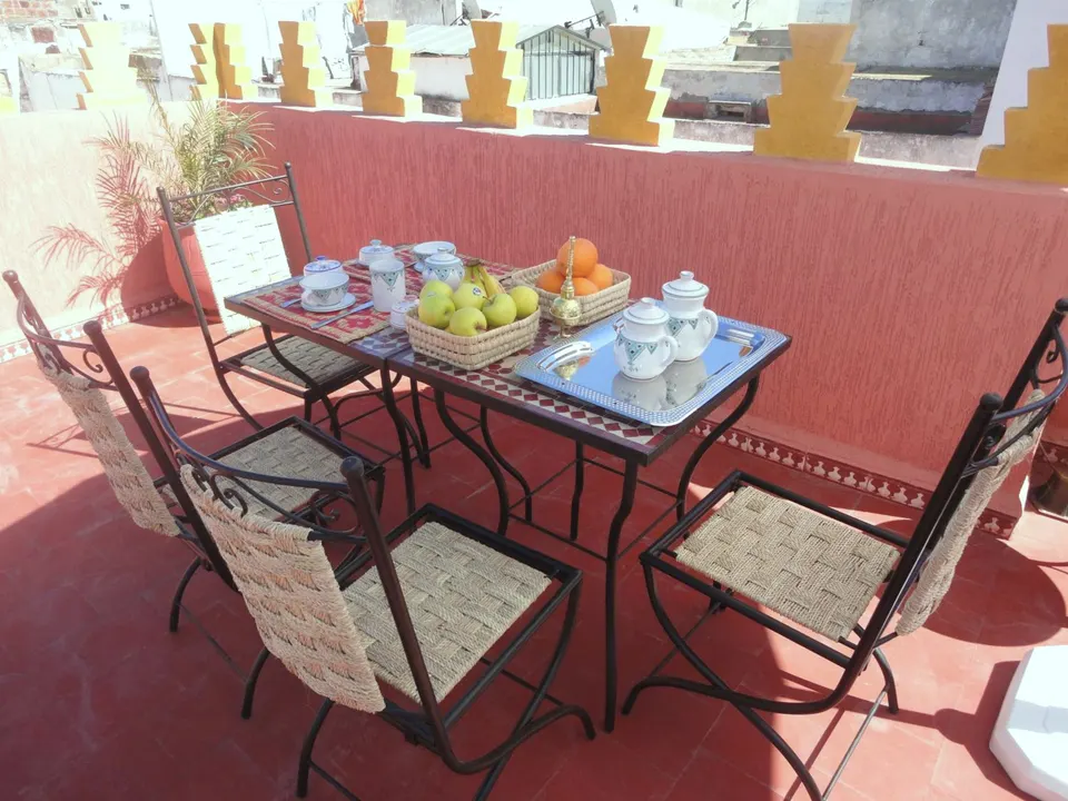 Breakfast table on the terrace: fruit baskets, cups, a mosaic table