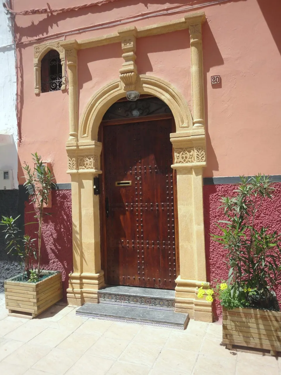 The door of Dar Yanis: carved stone arch, cedar door, number 20