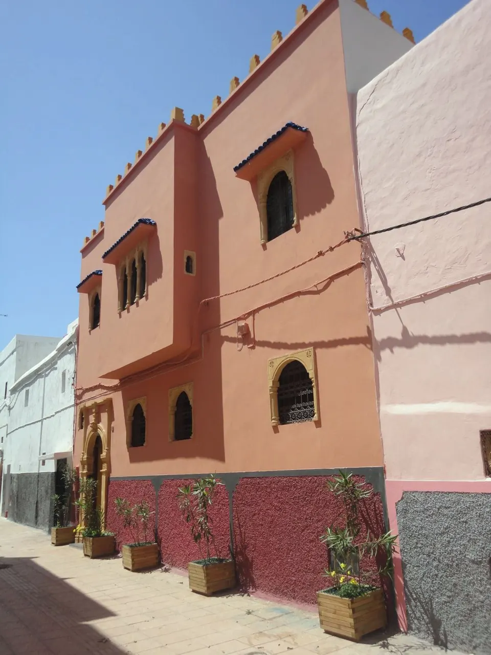 The pink house with its raspberry lower wall in the sunny lane