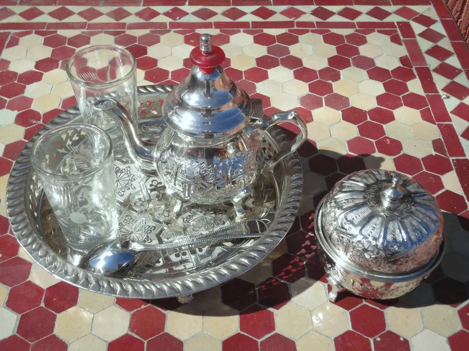 Silver tea tray and glasses on a mosaic table